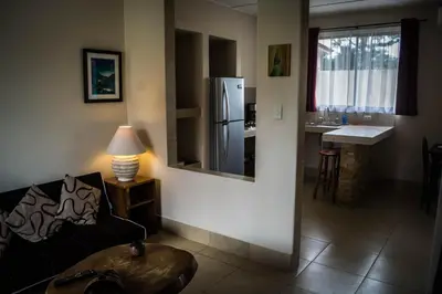 a living room with a couch and a refrigerator at Villa Creole in Jacó