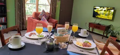 a table with plates of food and glasses of orange juice at Cassidini House in Monteverde Costa Rica