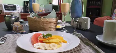 a plate of fruit on a table with wine glasses at Cassidini House in Monteverde Costa Rica
