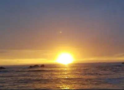 a sunset over the ocean with the sun setting at casa de playa Paraíso terrenal in San Juanillo