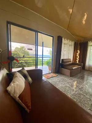 a living room with a couch and a large window at Ferreto`s House in El Castillo de La Fortuna