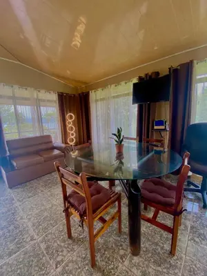 a dining room with a glass table and two chairs at Ferreto`s House in El Castillo de La Fortuna