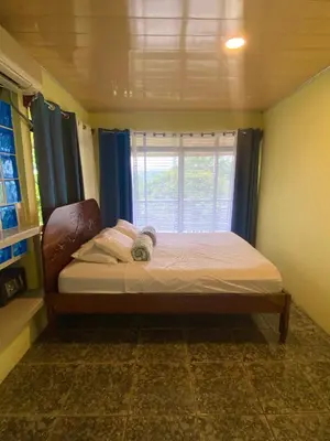 a small bed in a room with a window at Ferreto`s House in El Castillo de La Fortuna