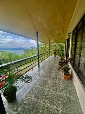 a balcony with plants and a view of the ocean at Ferreto`s House in El Castillo de La Fortuna