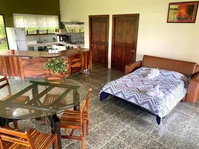 a living room with a table and a bed at Ferreto`s House in El Castillo de La Fortuna