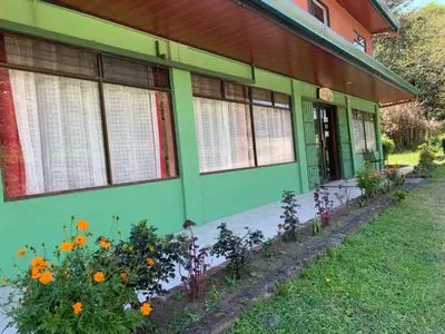 a green building with flowers in front of it at Globi Lodge 1 in Monteverde Costa Rica