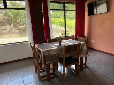 a dining room with a table and chairs and a window at Globi Lodge 1 in Monteverde Costa Rica