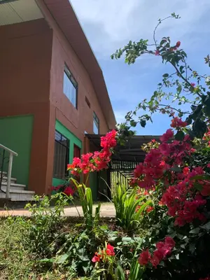 a building with pink flowers in front of it at Globi Lodge 1 in Monteverde Costa Rica