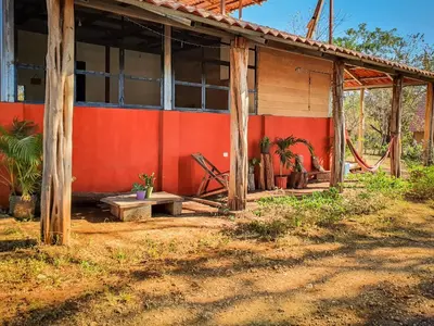 an old building with a red wall and some plants at Casa Ital-Tico, Playa Negra in Playa Negra