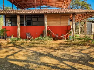 a red house with a red wall at Casa Ital-Tico, Playa Negra in Playa Negra
