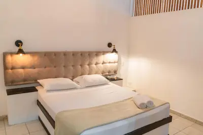 a bedroom with a large bed with a padded headboard at Plaza Royal Apartments in Santa Teresa Beach