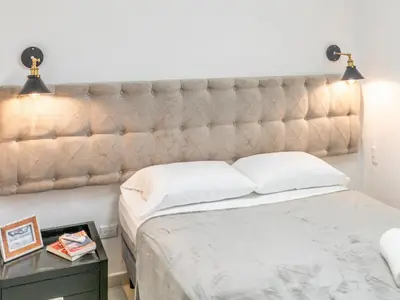 a bed with a tufted headboard in a bedroom at Plaza Royal Apartments in Santa Teresa Beach