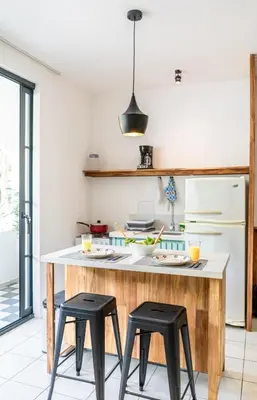 a kitchen with a island with two black stools at Plaza Royal Apartments in Santa Teresa Beach