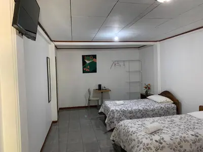 a room with two beds and a flat screen tv at Globi lodge #2 in Monteverde Costa Rica