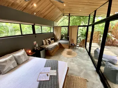 a bedroom with a bed and a living room at Villas Kalei in Playa Grande