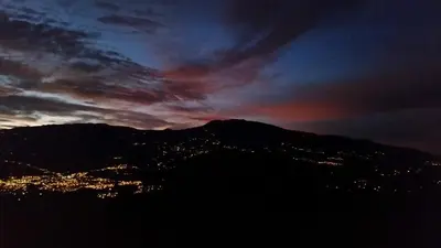 a view of a mountain with a city at night at Pochotel in Turrialba