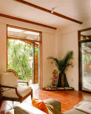 a living room with a couch and a window at Salty Enthusiasts Share House & Villas in Santa Teresa Beach