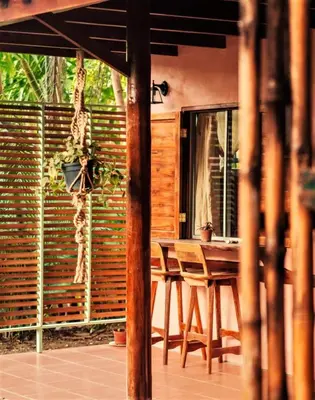 a wooden table and chairs on a patio at Salty Enthusiasts Share House & Villas in Santa Teresa Beach