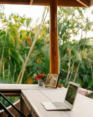 a laptop computer sitting on a table with a picture at Salty Enthusiasts Share House & Villas in Santa Teresa Beach