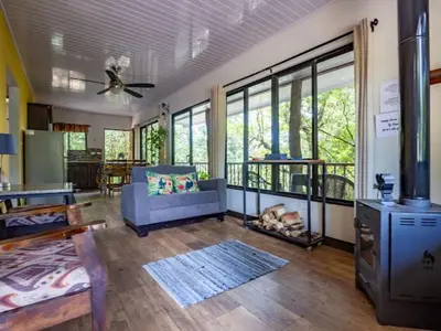 a living room with a couch and a stove at Cantos Del Bosque in Monteverde Costa Rica