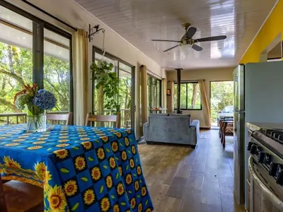 a living room with a table with a blue table cloth at Cantos Del Bosque in Monteverde Costa Rica