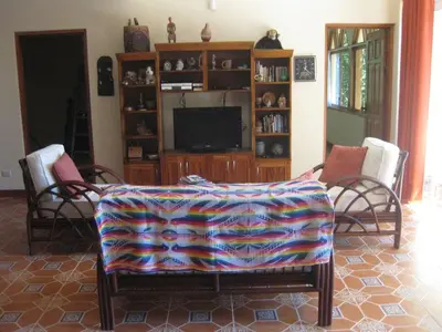 a living room with a couch and a tv at Villa Vista Verde Ground Floor Home, Save Hundreds on your trip, Reduced Prices on Tours in Quepos
