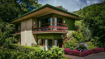 a green house with a balcony on top of it at Ficus Sunset Suites in Monteverde Costa Rica