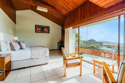 a bedroom with a bed and a balcony at Ficus Sunset Suites in Monteverde Costa Rica
