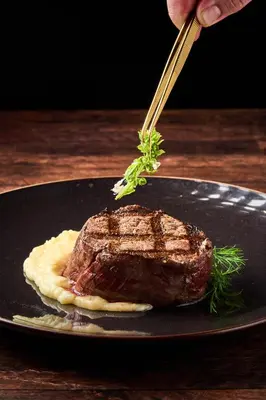 a piece of meat on a black plate with a fork at Ficus Sunset Suites in Monteverde Costa Rica