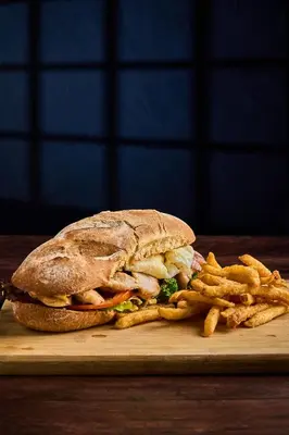 a sandwich and french fries on a wooden board at Hotel Heliconia - Monteverde in Monteverde Costa Rica