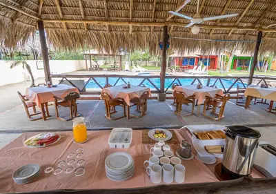 a table with food on it in a restaurant with a pool at Hotel Guanacaste Lodge in Playa Flamingo