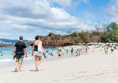 a man and a woman walking on a beach at Hotel Guanacaste Lodge in Playa Flamingo