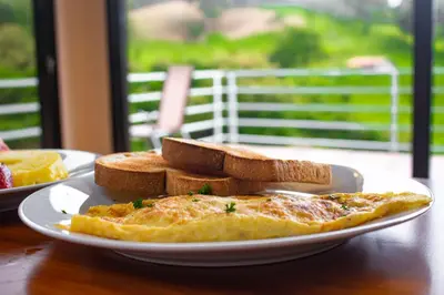 a plate of omelet and bread on a table at Burbi Lake Lodge Monteverde in Monteverde Costa Rica