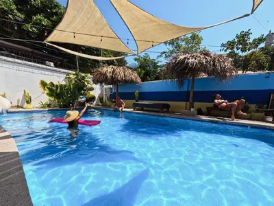 a group of people swimming in a swimming pool at La Posada - Hostel in Santa Teresa Beach