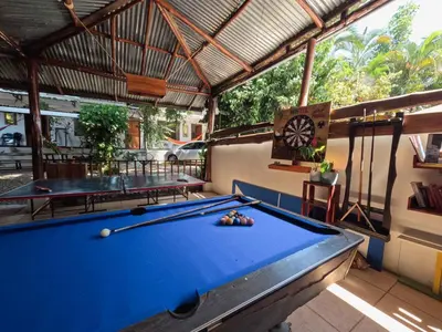 a pool table in a pavilion with two tables at La Posada - Hostel in Santa Teresa Beach
