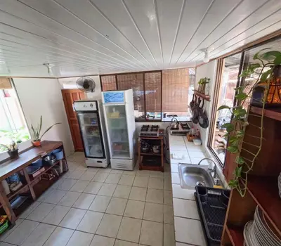 a kitchen with a sink and a refrigerator at La Posada - Hostel in Santa Teresa Beach
