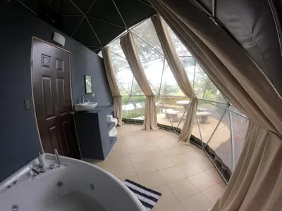 a large bathroom with a tub and a large window at Cabaña del Lago in Cuatro Esquinas