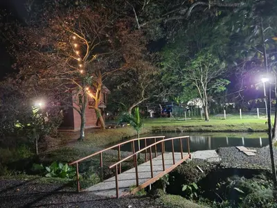 a wooden bridge over a pond at night at Cabaña del Lago in Cuatro Esquinas