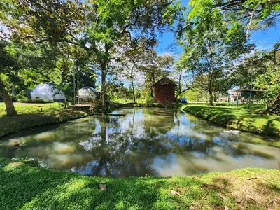 a river with a barn in the background at Cabaña del Lago in Cuatro Esquinas