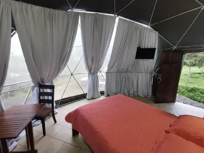 a bedroom with a bed and a large window at Cabaña del Lago in Cuatro Esquinas