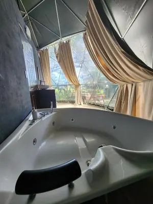 a large white bath tub in a room with a window at Cabaña del Lago in Cuatro Esquinas
