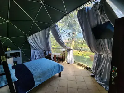 a room with a bed and a large window at Cabaña del Lago in Cuatro Esquinas