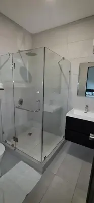 a bathroom with a glass shower and a sink at Hotel Green Jacó in Jacó