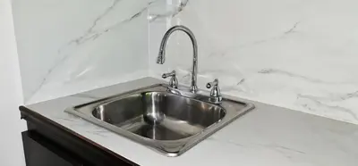 a stainless steel sink in a white counter top at Hotel Green Jacó in Jacó