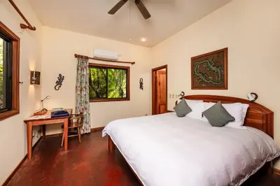 a bedroom with a bed and a desk and a window at Boutique Hotel Luna Azul in Playa Ostional