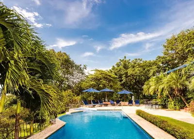 a swimming pool with blue chairs and umbrellas at Boutique Hotel Luna Azul in Playa Ostional