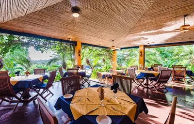 a restaurant with tables and chairs and large windows at Boutique Hotel Luna Azul in Playa Ostional