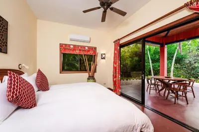 a bedroom with a bed and a patio with a table at Boutique Hotel Luna Azul in Playa Ostional