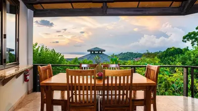 a table and chairs on a balcony with a view at Tulemar in Manuel Antonio
