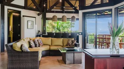 a living room with a couch and a table at Tulemar in Manuel Antonio